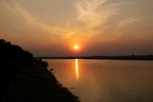 Sunset view over the Chobe River with reflections on the water surface.