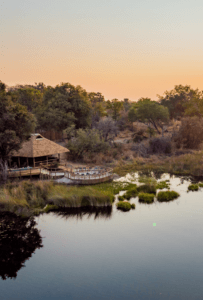 A sunset sky with a front view of the lodge, enjoy our 5 night package at Kwara and 4 Rivers
